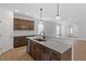 Bright kitchen with white backsplash, stainless steel dishwasher, island sink, and dark brown cabinetry at 209 Meadowbark Bnd # 20, Garner, NC 27529
