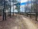 Gravel driveway entrance with wooden fence and metal gate at 330 Ellis Stewart Ln Ln, Cameron, NC 28326