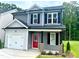 Two-story house with gray siding, red door, and a two-car garage at 382 Maidenhair Pl, Clayton, NC 27520