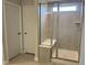 Bathroom featuring tiled shower with frameless door and bench, next to a white door at 3854 Well Fleet Drive, Fuquay Varina, NC 27526