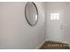 Bright entryway with a round mirror, white door, and wood-look flooring, offering a welcoming space at 3854 Well Fleet Drive, Fuquay Varina, NC 27526
