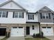 Townhomes with stone accents, attached garages, and well-maintained landscaping at 3854 Well Fleet Drive, Fuquay Varina, NC 27526