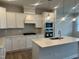 Bright kitchen featuring stainless steel appliances, white cabinetry, quartz counters, and pendant lighting at 3854 Well Fleet Drive, Fuquay Varina, NC 27526