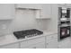 Close-up of modern stainless steel appliances, sleek cooktop, and stylish white cabinetry in the kitchen at 3854 Well Fleet Drive, Fuquay Varina, NC 27526