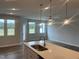 Kitchen open to the living space featuring a quartz countertop island and pendant lighting at 3854 Well Fleet Drive, Fuquay Varina, NC 27526