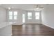 Bright living area boasts hardwood floors, a ceiling fan, and multiple windows for ample natural light at 3854 Well Fleet Drive, Fuquay Varina, NC 27526