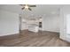Expansive living room showcasing an open layout with hardwood floors and a modern kitchen with stainless appliances at 3854 Well Fleet Drive, Fuquay Varina, NC 27526