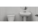 Compact bathroom with a toilet, pedestal sink and circular mirror at 3860 Well Fleet Drive, Fuquay Varina, NC 27526