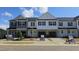 New townhomes with stone accents, black shutters and convenient garages create an appealing street view at 3860 Well Fleet Drive, Fuquay Varina, NC 27526