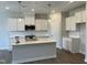 Modern kitchen features white cabinetry, quartz countertops, stainless steel appliances and an island with a sink at 3860 Well Fleet Drive, Fuquay Varina, NC 27526