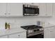 Modern kitchen features stainless steel appliances, white cabinetry, and beautiful herringbone backsplash at 3860 Well Fleet Drive, Fuquay Varina, NC 27526