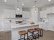 Bright kitchen featuring white cabinets, stainless steel appliances and a large island with stool seating at 3860 Well Fleet Drive, Fuquay Varina, NC 27526