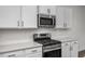 Modern kitchen with stainless steel appliances, a gas range, and white backsplash at 3860 Well Fleet Drive, Fuquay Varina, NC 27526