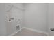 Bright laundry room featuring gray paint, tile flooring, and wire shelving at 3860 Well Fleet Drive, Fuquay Varina, NC 27526