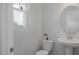 Cozy powder room featuring pedestal sink, toilet, and window for natural light at 3860 Well Fleet Drive, Fuquay Varina, NC 27526