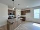 Bright kitchen boasts a granite island, stainless appliances, and pendant lighting at 394 Maidenhair Pl, Clayton, NC 27520