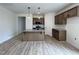 Open kitchen features a granite island, stainless appliances, and wood-look flooring at 394 Maidenhair Pl, Clayton, NC 27520