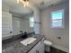 Modern bathroom with granite countertop, white cabinets, and a window for natural light at 406 Maidenhair Pl, Clayton, NC 27520