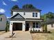 Charming two-story home featuring light gray siding, an attached garage, and manicured front landscaping at 406 Maidenhair Pl, Clayton, NC 27520