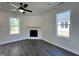 Cozy living room featuring a fireplace, wood floors, a ceiling fan, and natural lighting at 406 Maidenhair Pl, Clayton, NC 27520