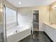 Bathroom with corner bathtub, double vanity and tiled floor at 4109 Mangrove Dr, Raleigh, NC 27616
