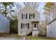 Two-story house with beige siding, black shutters, and a small front porch at 412 N Cooper St, Clayton, NC 27520