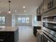 Modern kitchen featuring stainless appliances, shaker cabinets, quartz countertops, and hardwood flooring at 4318 Emeline Ln # 20, Fuquay Varina, NC 27526