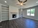 Cozy living room with a ceiling fan, fireplace, built-in shelves, and hardwood flooring at 45 Mossman Ct, Zebulon, NC 27597