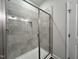 Stylish walk-in shower featuring glass doors and neutral tile at 45 Mossman Ct, Zebulon, NC 27597