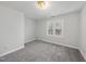 Spacious bedroom with grey carpet and a window with natural light at 5120 Tallwood Dr, Raleigh, NC 27613