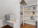 Hallway seating area with decorative shelving, pillows, and dark wood floors at 700 Coleman St, Raleigh, NC 27610
