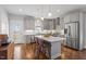 Modern kitchen with stainless appliances, gray cabinetry, and island with bar stool seating at 700 Coleman St, Raleigh, NC 27610