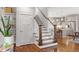 Elegant staircase with wooden banister, leading to an open kitchen with stainless steel appliances at 700 Coleman St, Raleigh, NC 27610