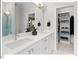 Bathroom featuring double sinks, white cabinetry, and a view of the walk-in closet with custom shelving at 712 E Edenton St # 105, Raleigh, NC 27601