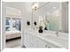 Bright bathroom featuring double sinks, quartz counters, large mirror, and a glass shower with tiled walls at 712 E Edenton St # 105, Raleigh, NC 27601