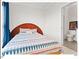 Bedroom with a plush bed adorned with patterned linens and a view into the ensuite bathroom at 712 E Edenton St # 105, Raleigh, NC 27601