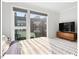 Cozy bedroom showcasing a queen-size bed, sleek dresser, and large windows with views of the neighborhood at 712 E Edenton St # 105, Raleigh, NC 27601