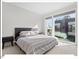 Bright bedroom with large windows, plush bed, and modern nightstand at 712 E Edenton St # 105, Raleigh, NC 27601