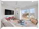 Bright living room features a large sectional sofa, a ceiling fan, and a large window with neighborhood views at 712 E Edenton St # 105, Raleigh, NC 27601