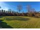 Spacious backyard with manicured lawn and stone wall at 7845 Hasentree Lake Dr, Wake Forest, NC 27587