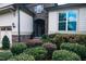 House entrance with stone accents, landscaping, and a two-car garage at 7845 Hasentree Lake Dr, Wake Forest, NC 27587