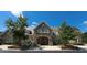 Stone clubhouse exterior with arched entryway, manicured landscaping, and golf cart parked outside at 7845 Hasentree Lake Dr, Wake Forest, NC 27587