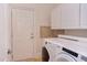 Bright laundry room with washer, dryer and cabinets at 7845 Hasentree Lake Dr, Wake Forest, NC 27587