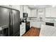 Bright kitchen with white cabinets, granite counters, and black appliances at 1134 Bowling Mountain Dr, Stem, NC 27581