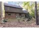 Rear view of a two-story home with brick accents, a cozy patio, and a lush, leaf-covered backyard at 11509 Hardwick Ct, Raleigh, NC 27614