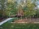 Serene view of a home nestled amongst trees with a long driveway winding through a wooded landscape at 11509 Hardwick Ct, Raleigh, NC 27614