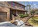 Inviting home entrance with a brick facade, wooden steps, landscaped bushes, and a curved walkway at 11509 Hardwick Ct, Raleigh, NC 27614