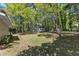 Backyard with lush trees and outbuilding surrounded by green grass at 1304 Rothes Rd, Cary, NC 27511