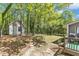 Secluded backyard featuring lush trees, outbuilding and brick paver path at 1304 Rothes Rd, Cary, NC 27511
