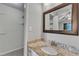 Neutral bathroom vanity with granite countertop, framed mirror, and walk-in closet at 1304 Rothes Rd, Cary, NC 27511